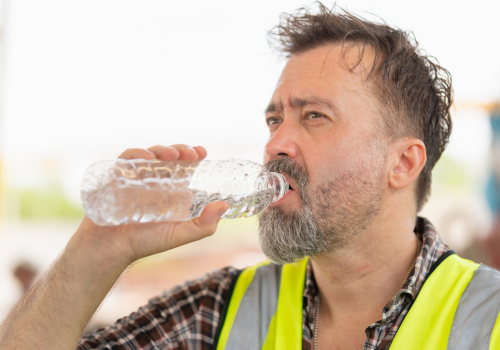 Caucasian engineer man drinking water at the precast factory site, Worker man drinking water at construction site