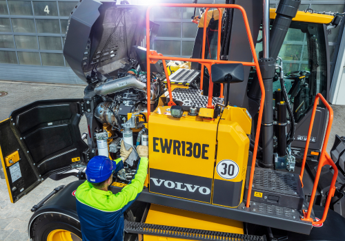 Volvo equipment operator cleaning excavator 